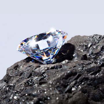 Diamond on a piece of black rock with a light gray background